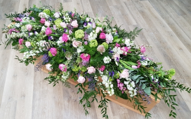 Graceful Farewell Funeral Spray with pink roses, soft purples, whites, mixed greens and soft trails of foliage